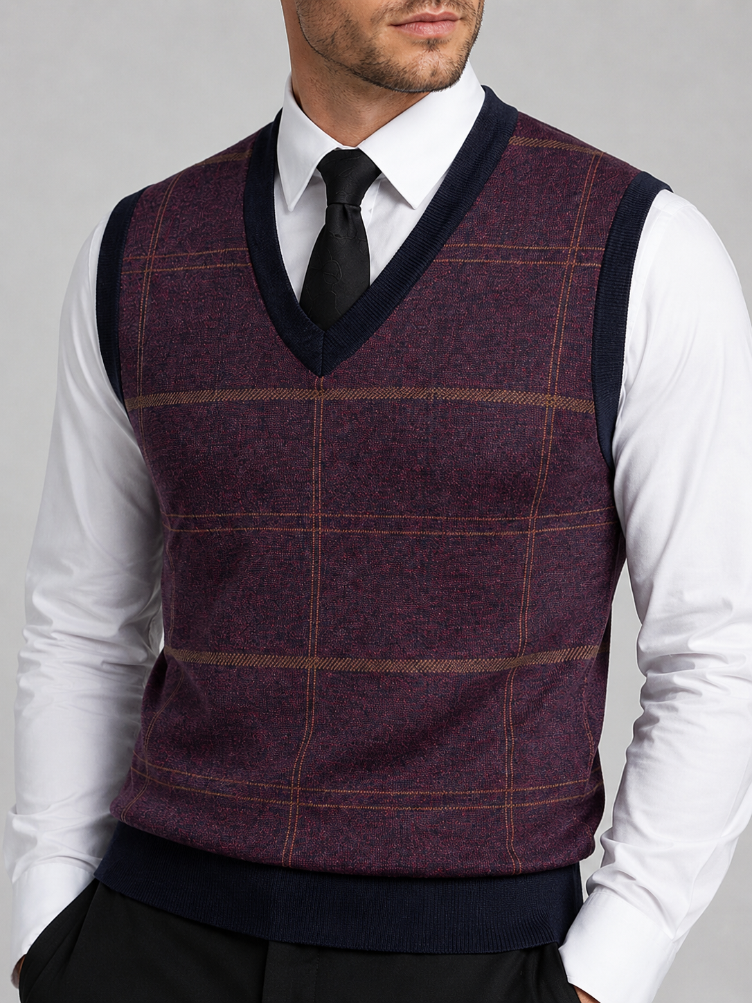 Close-up of a wine red V-neck sweater vest showing the diamond pattern, cable knit texture, ribbed neckline, armholes, and hem