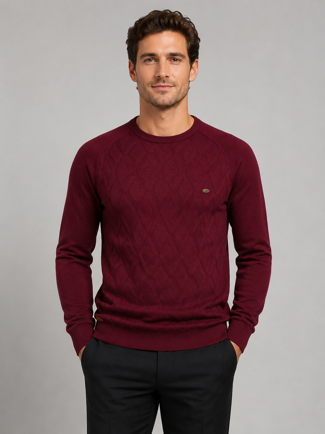 Front view of a man wearing a wine argyle crew neck sweater with long sleeves and a warm knit pattern