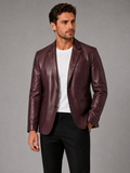 Front view of a man wearing a wine red leather blazer jacket with a slim fit, notched lapel, single-breasted design, and tailored silhouette