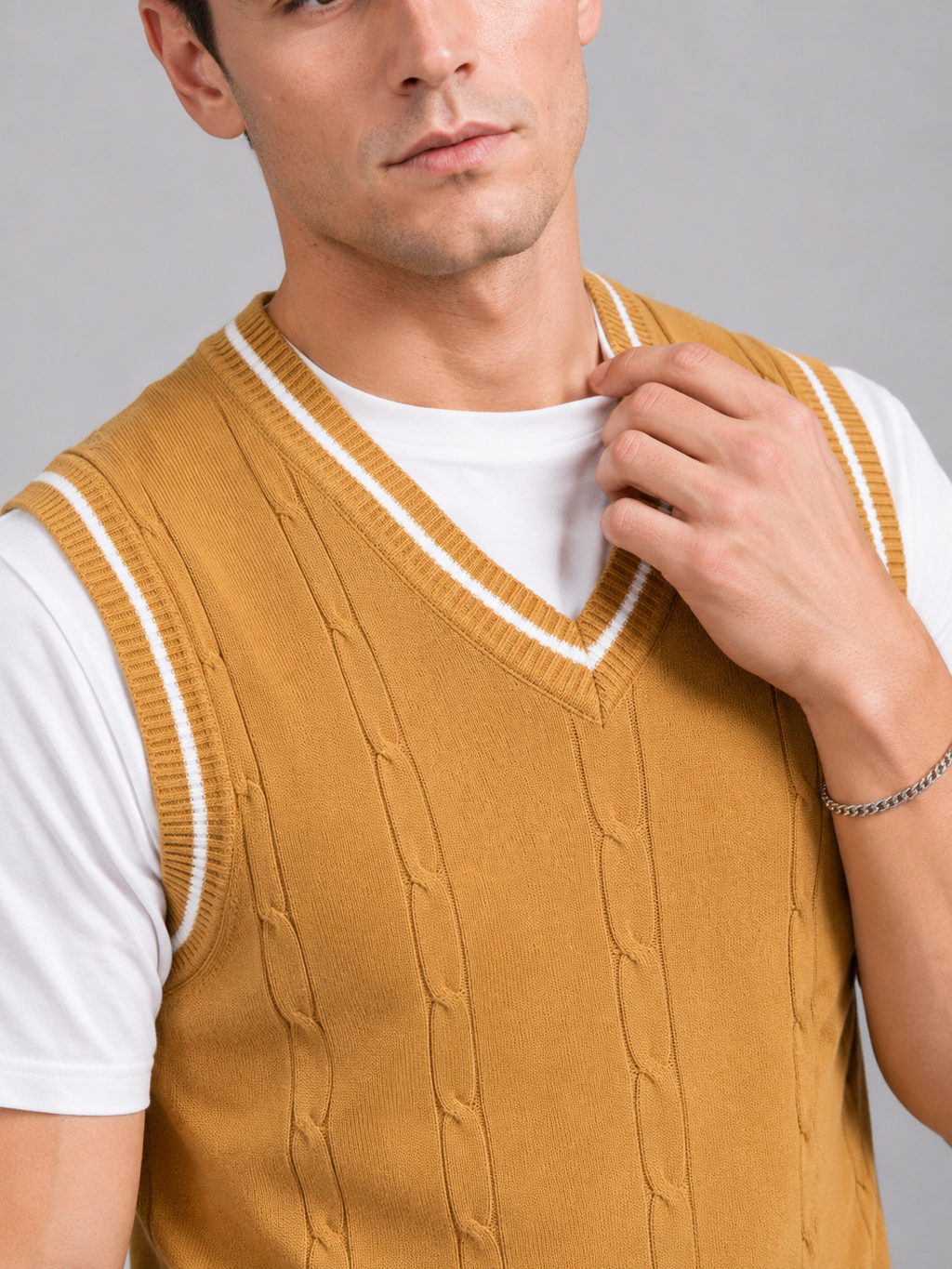 Close up of yellow patchwork sweater vest showing soft knit texture and classic v neck detail