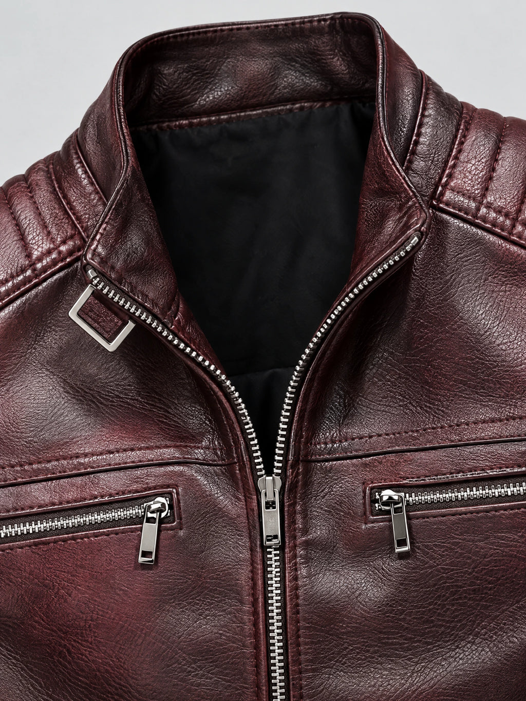 Close-up of the Red Biker Leather Jacket with textured PU leather, notched lapels, quilted shoulders, and silver zip pockets.