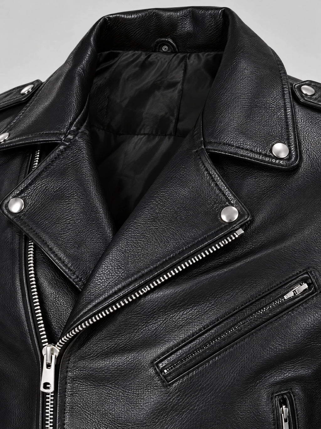 Close-up of a Black Biker Leather Jacket with textured PU leather, snap lapels, diagonal zipper, and zippered chest pocket.
