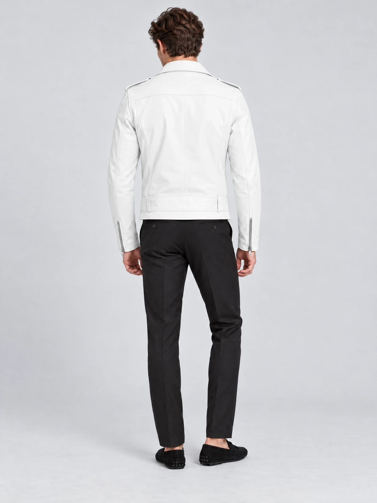 Rear studio view of a model wearing a White biker leather jacket with shoulder epaulets, back seams, and a belted hem.
