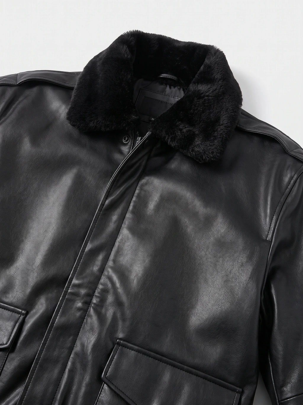 Close-up of the Black leather jacket showing its plush collar, front zipper, and flap pockets.