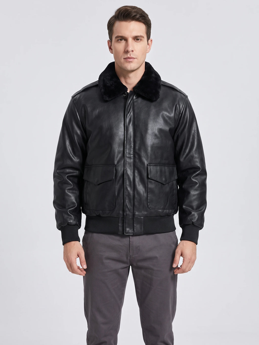 Front studio view of a model wearing a Black leather jacket with a plush collar, flap pockets, and ribbed cuffs and hem.