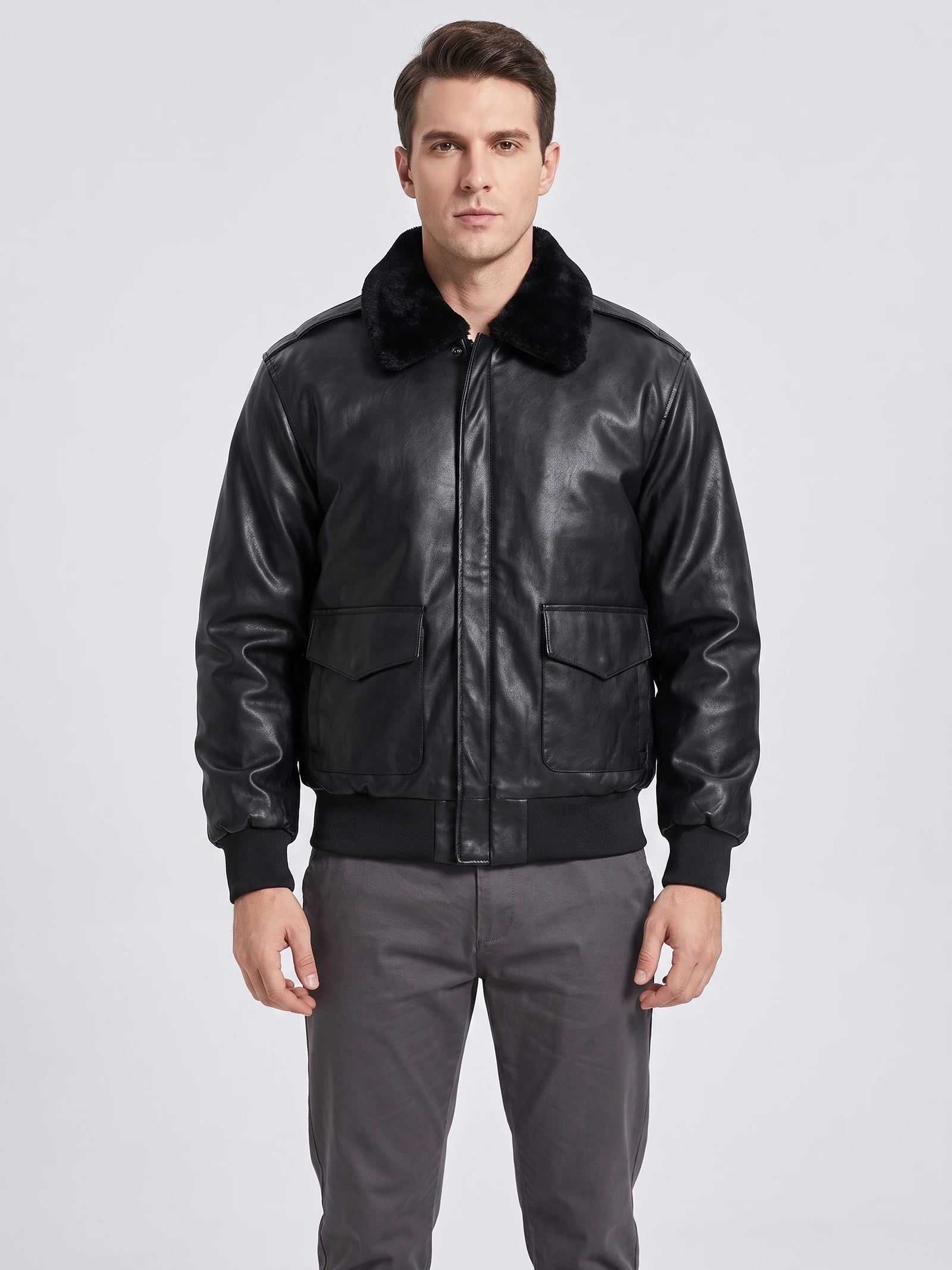 Front studio view of a model wearing a Black leather jacket with a plush collar, flap pockets, and ribbed cuffs and hem.