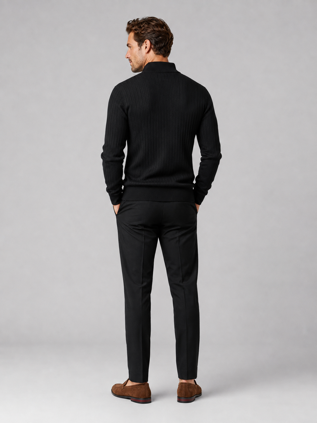 Back view of a man wearing a black quarter zip sweater showing the long sleeves, clean knit construction, and comfortable fit