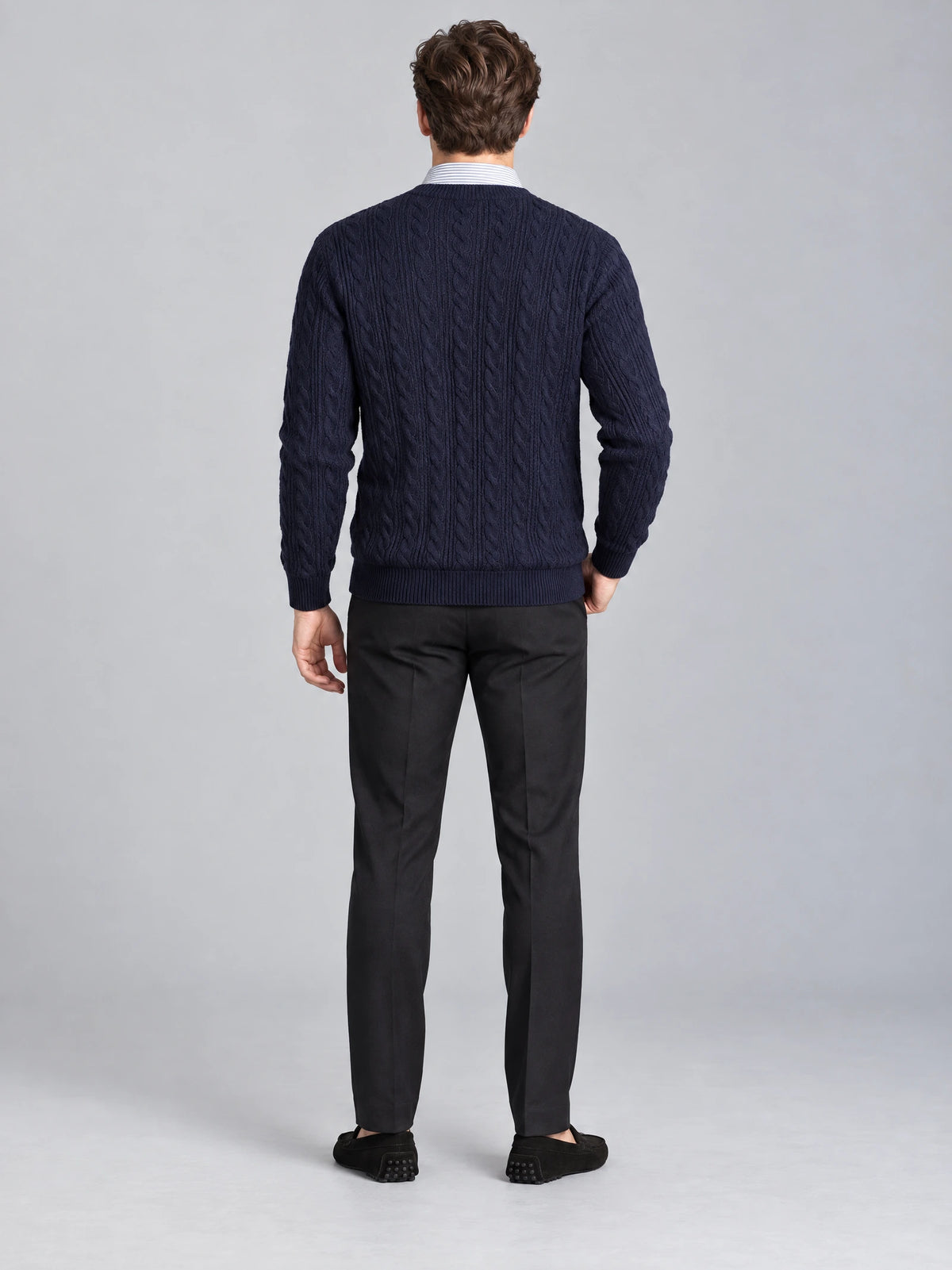 Rear view of a model wearing a Navy business casual knitted pullover sweater with cable-knit texture and ribbed trim.