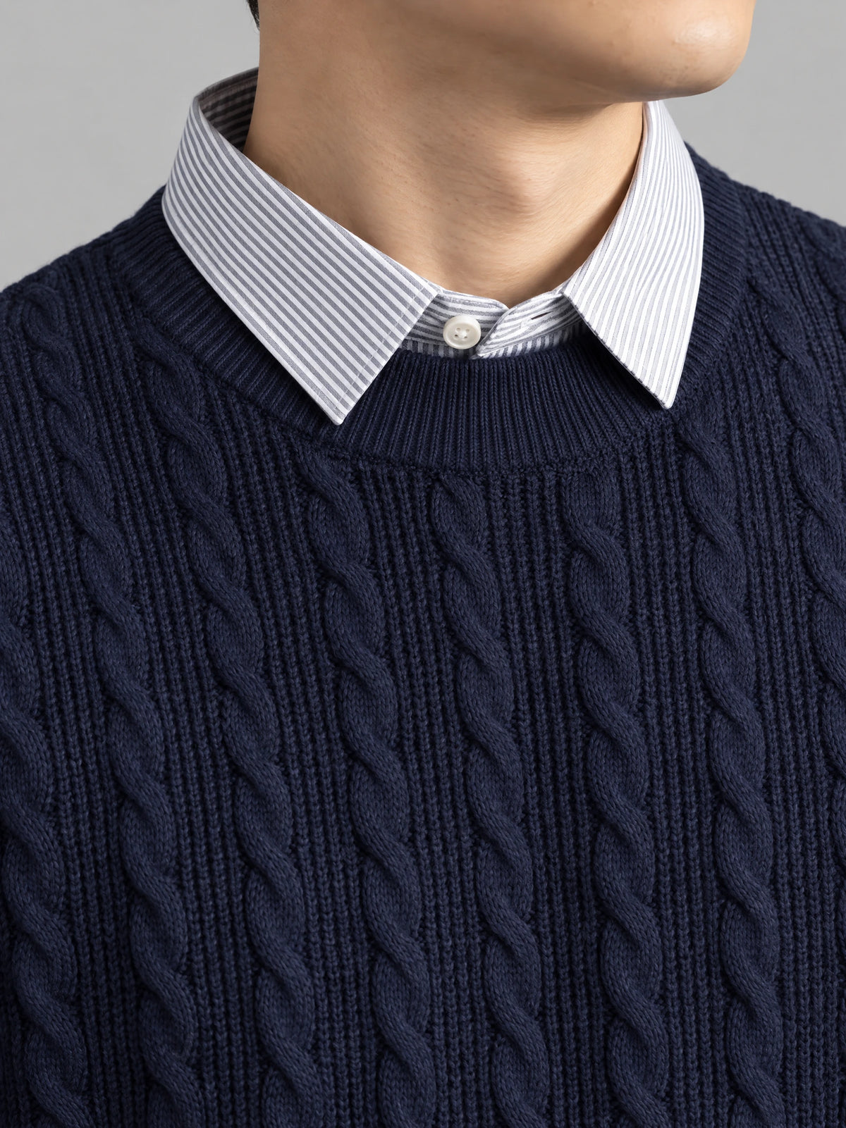 Close-up of the Navy Business Casual Knitted Pullover Sweater with cable-knit texture and a striped faux shirt collar.