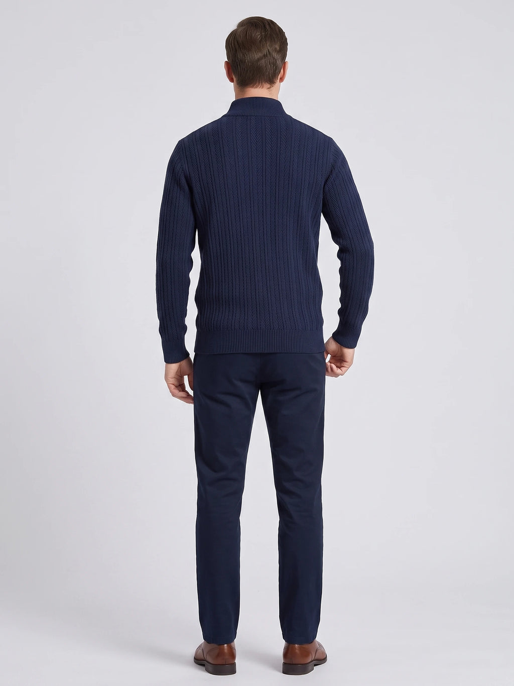 Rear studio view of a model wearing a Navy button up cardigan with textured vertical knit pattern and ribbed stand collar.