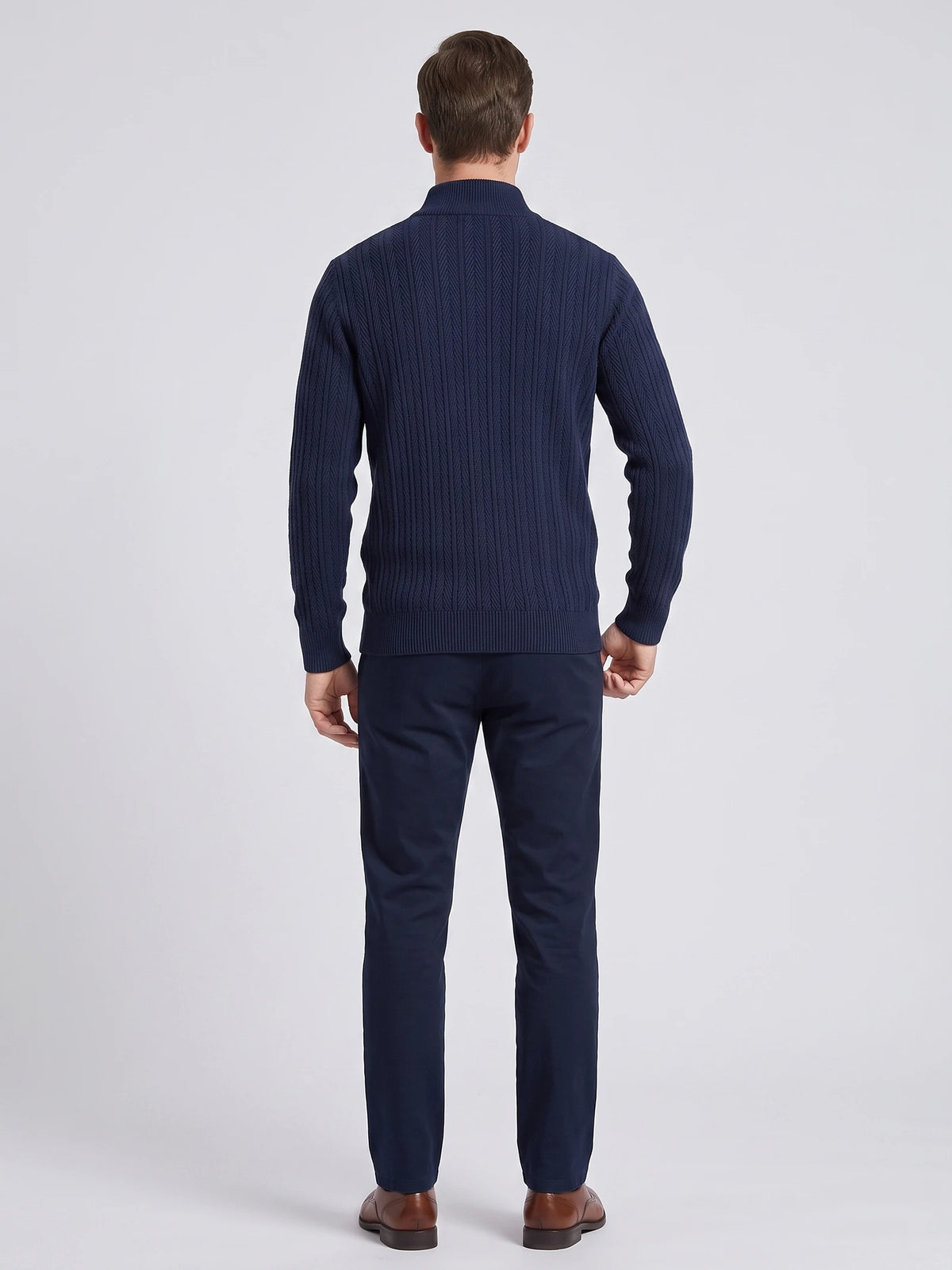 Rear studio view of a model wearing a Navy button up cardigan with textured vertical knit pattern and ribbed stand collar.