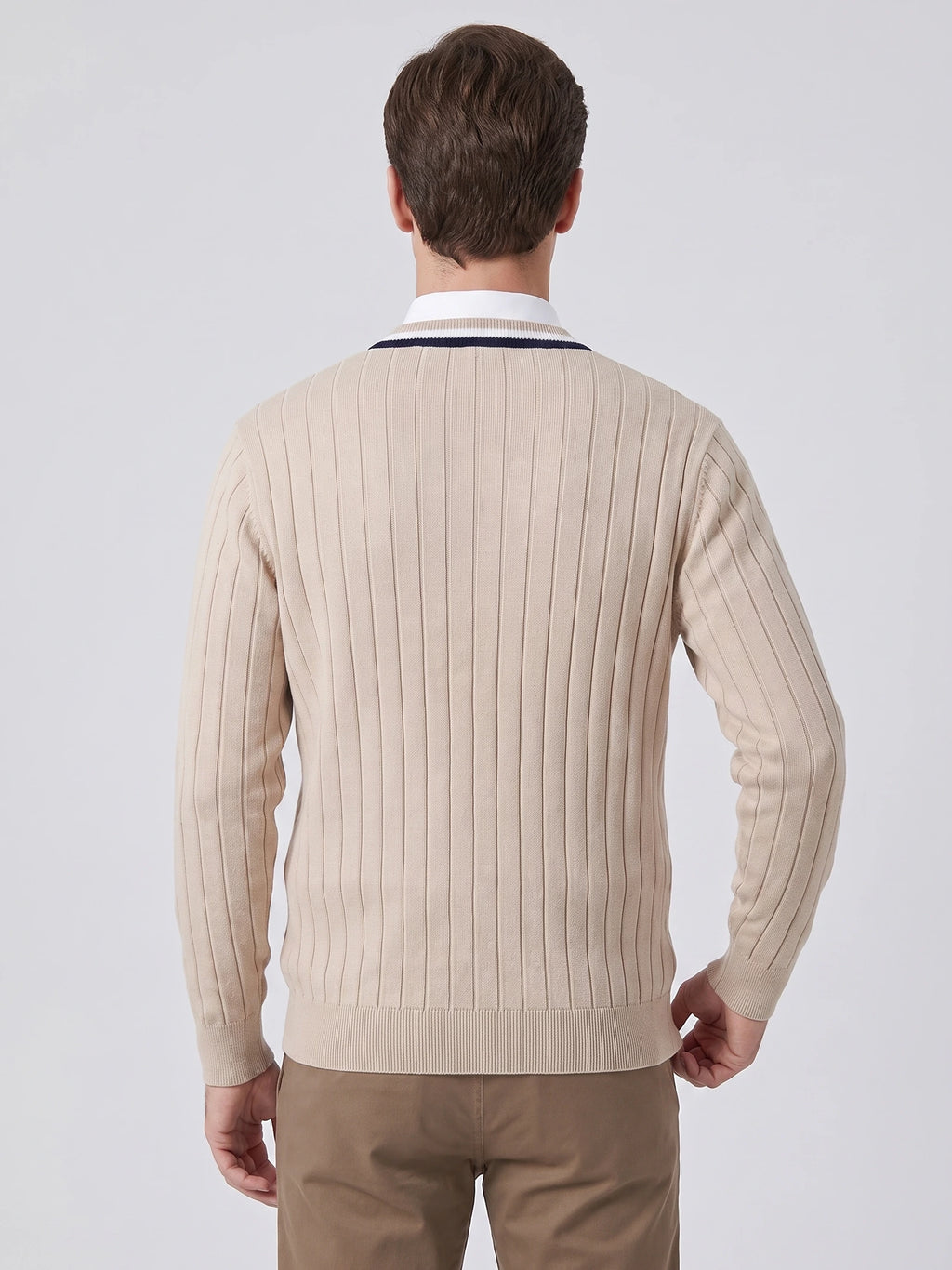 Rear studio view of a model wearing a Beige cotton Cardigan Sweater with vertical ribbed knit texture and ribbed hem and cuffs.