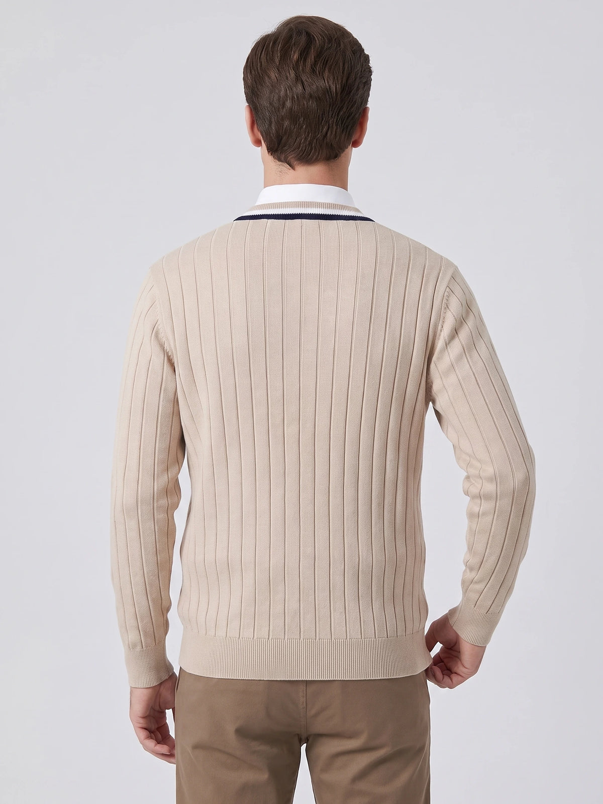 Rear studio view of a model wearing a Beige cotton Cardigan Sweater with vertical ribbed knit texture and ribbed hem and cuffs.