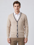 Front studio view of a model wearing a Beige cotton Cardigan Sweater with a ribbed V-neck, button front, and vertical knit texture.