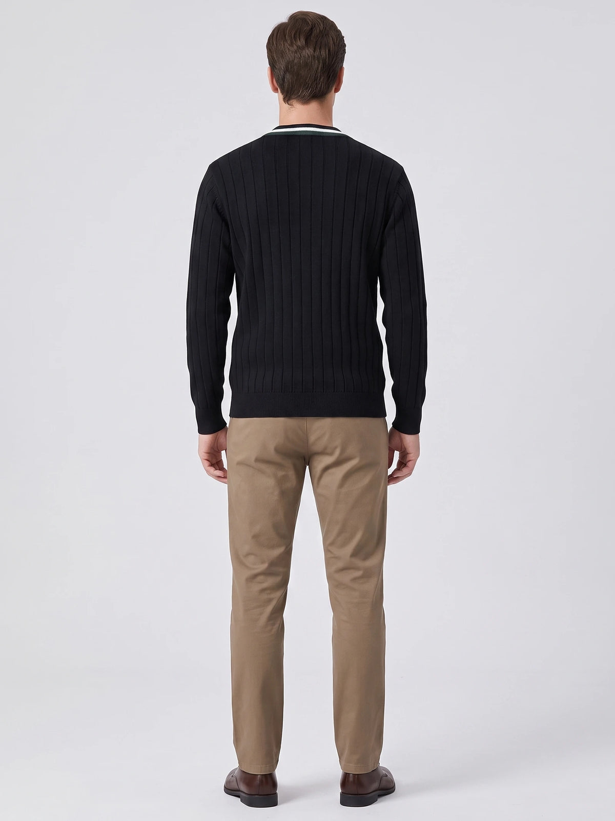 Rear studio view of a model wearing a Black cotton Cardigan Sweater with vertical ribbed knit texture and striped collar trim.