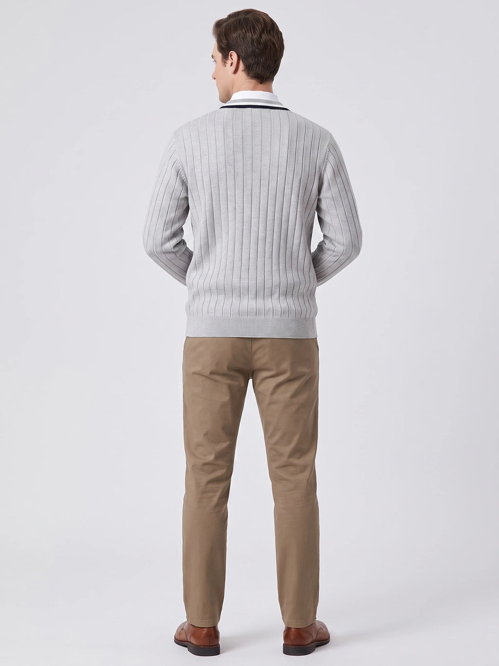 Rear studio view of a model wearing a Gray cotton Cardigan Sweater with vertical ribbed knit detailing and a ribbed hem.