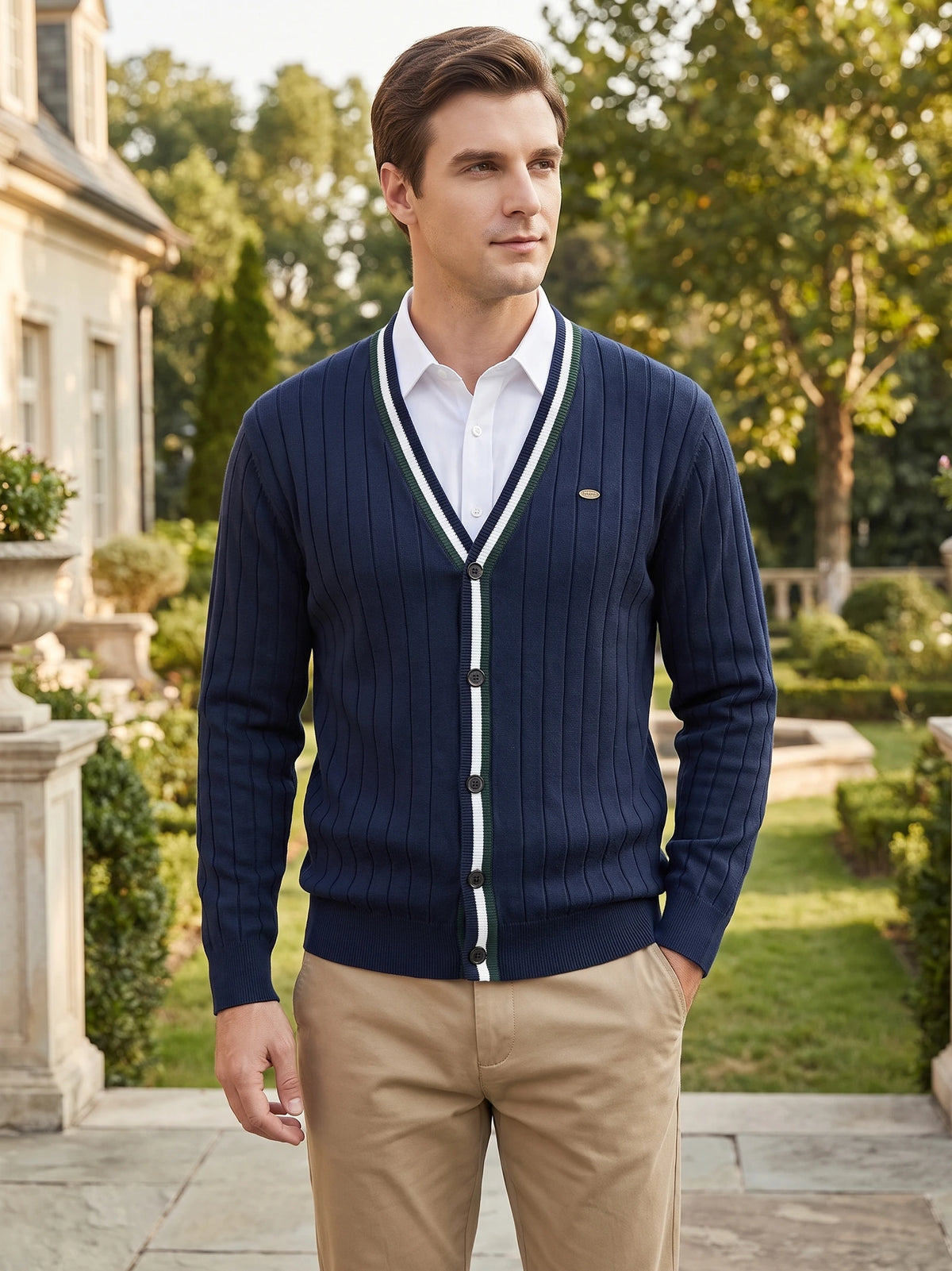 Model wearing a Navy cotton Cardigan Sweater with a striped V-neck and button front in a landscaped garden.