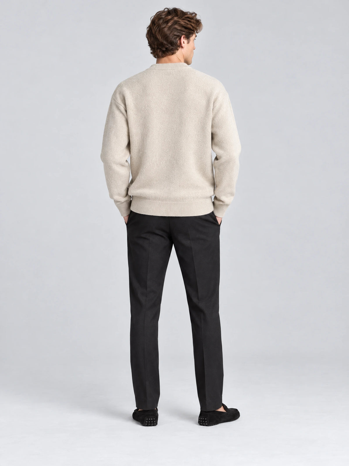 Rear studio view of a model wearing a Beige wool Cardigan Sweater with ribbed collar, cuffs, and hem.