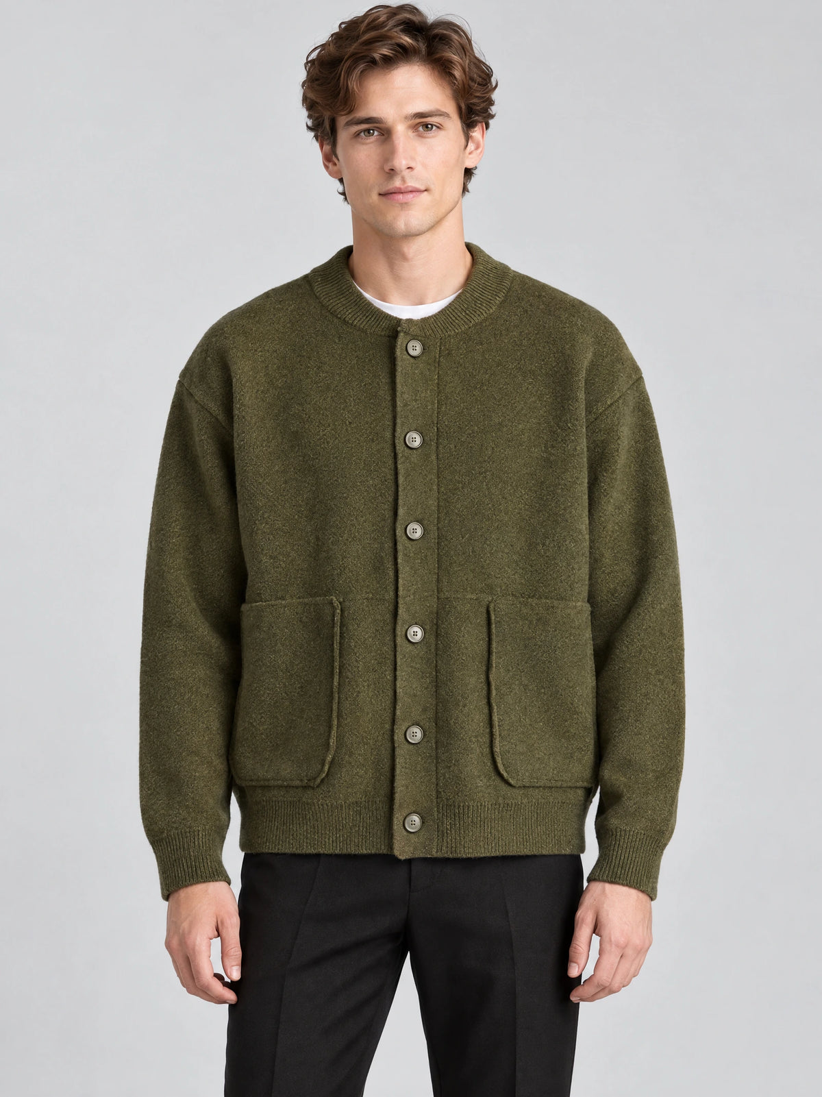 Front studio view of a model wearing a Green wool Cardigan Sweater with a round neck, button front, and patch pockets.