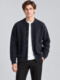 Front studio view of a model wearing a Navy wool Cardigan Sweater with a ribbed round neck, button front, and patch pockets.