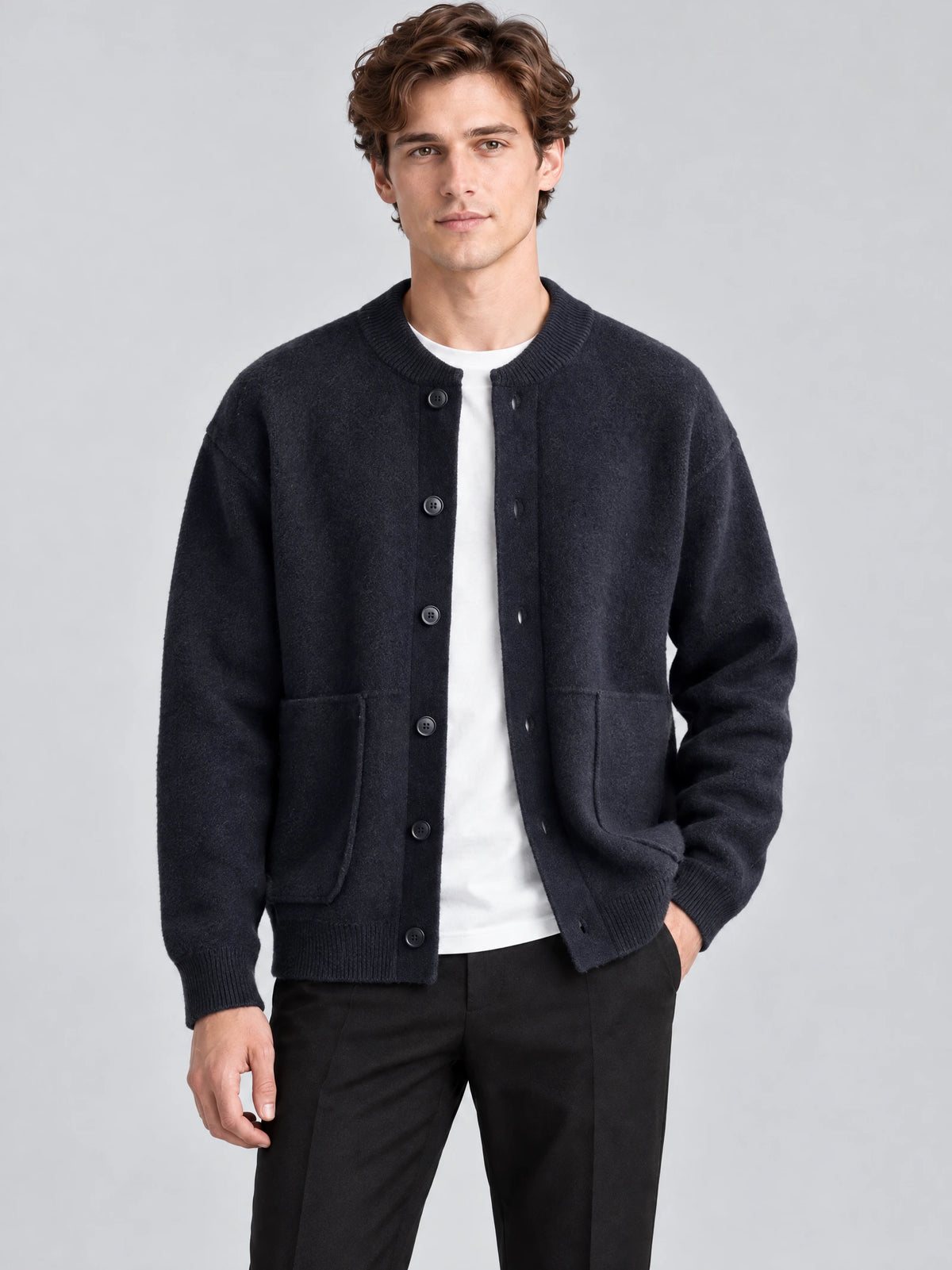Front studio view of a model wearing a Navy wool Cardigan Sweater with a ribbed round neck, button front, and patch pockets.
