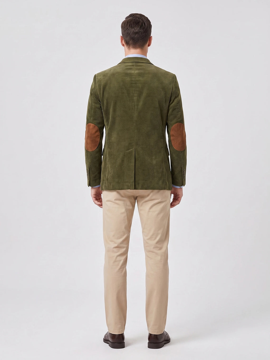 Rear studio view of a model wearing a Green corduroy blazer with elbow patches and a center back vent.