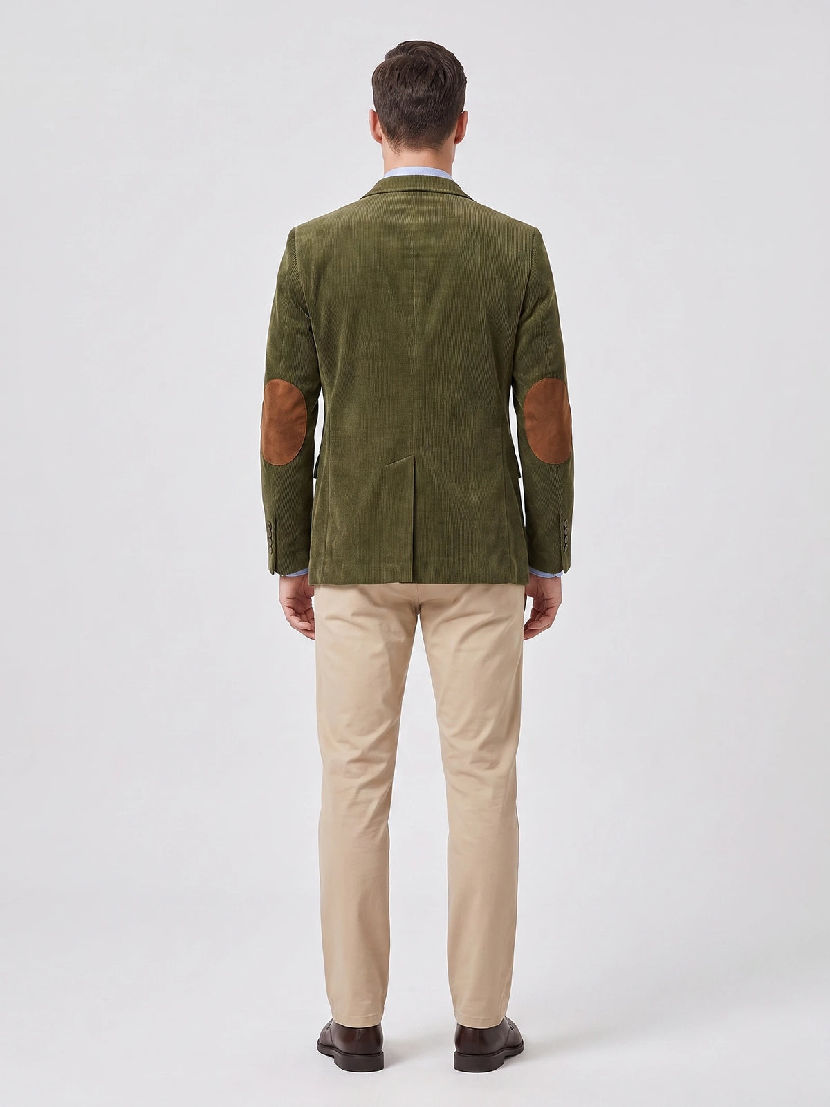 Rear studio view of a model wearing a Green corduroy blazer with elbow patches and a center back vent.