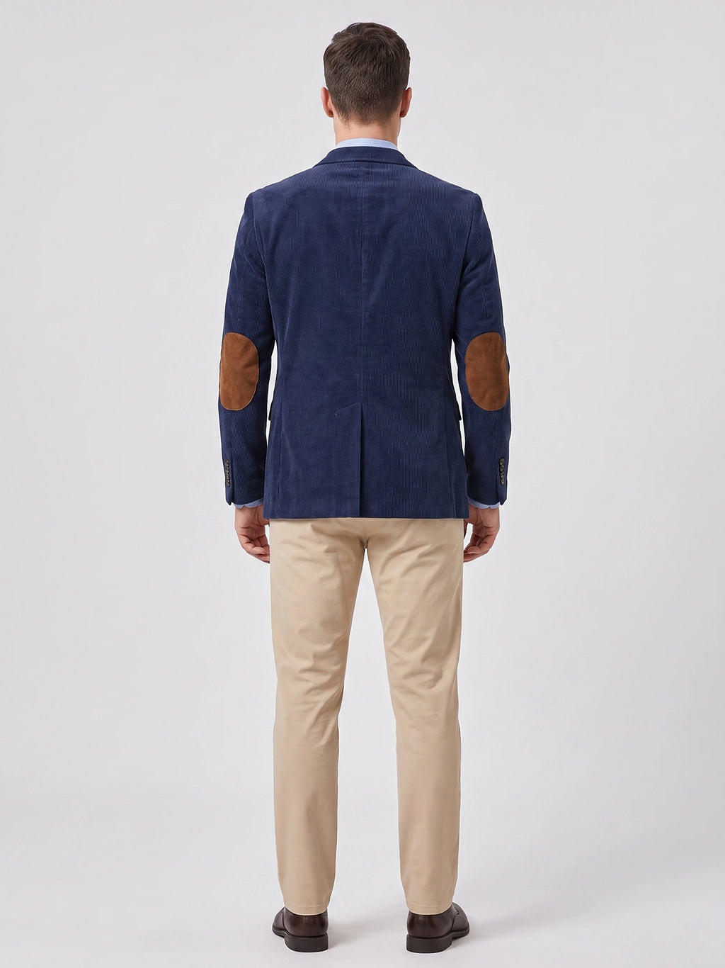 Rear view of a model wearing a Navy corduroy blazer with elbow patches and a center back vent.