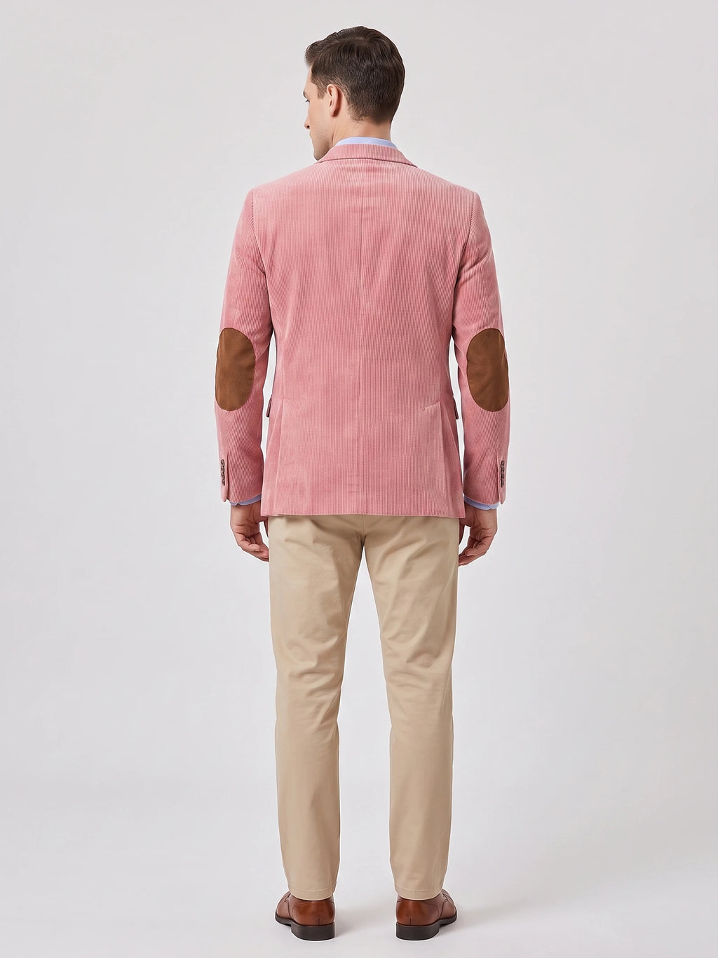 Rear studio view of a model wearing a Pink corduroy blazer with elbow patches and a center back seam.
