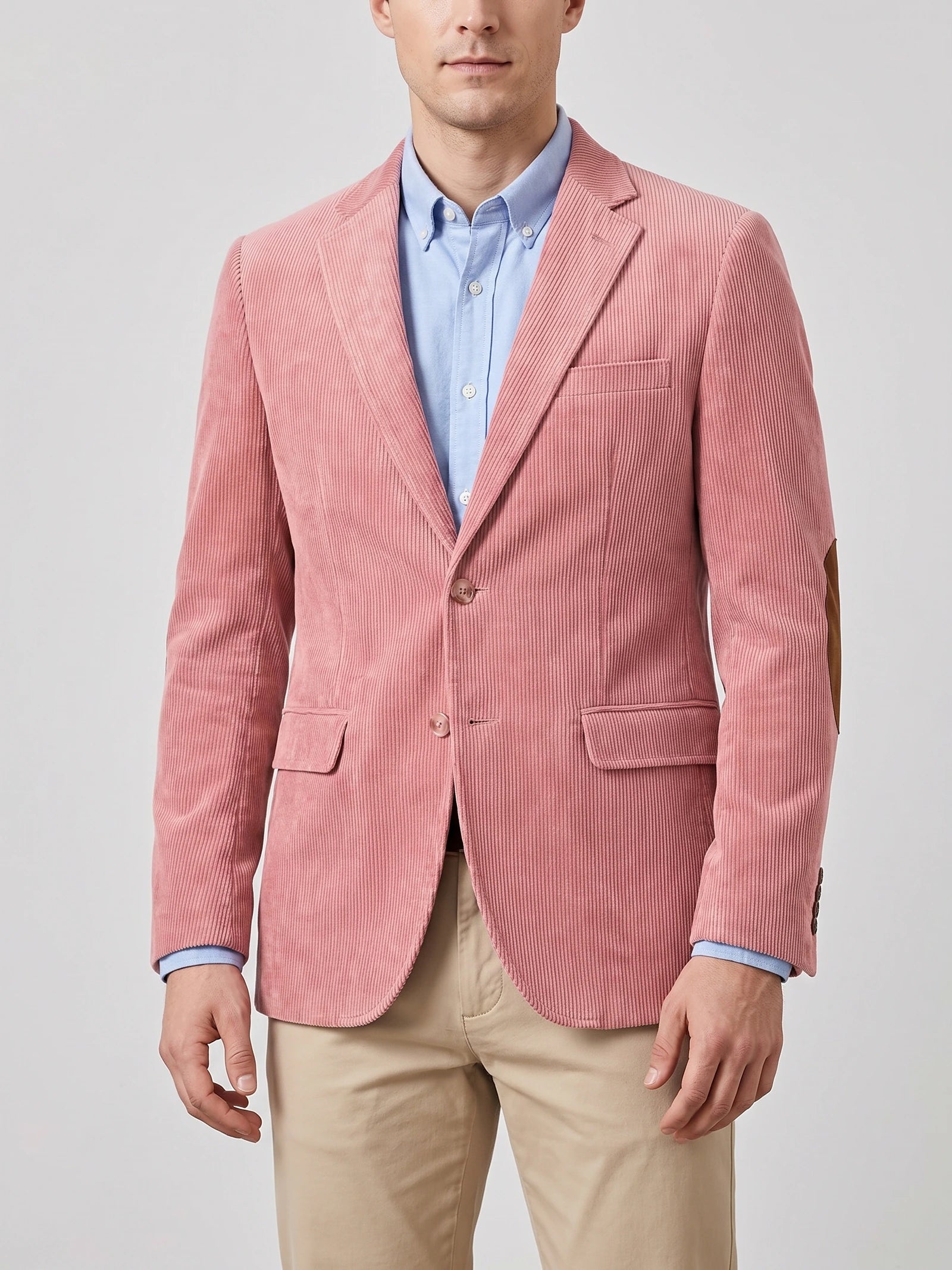 Front studio view of a model wearing a Pink corduroy blazer with notch lapels, flap pockets, two-button closure, and elbow patches.