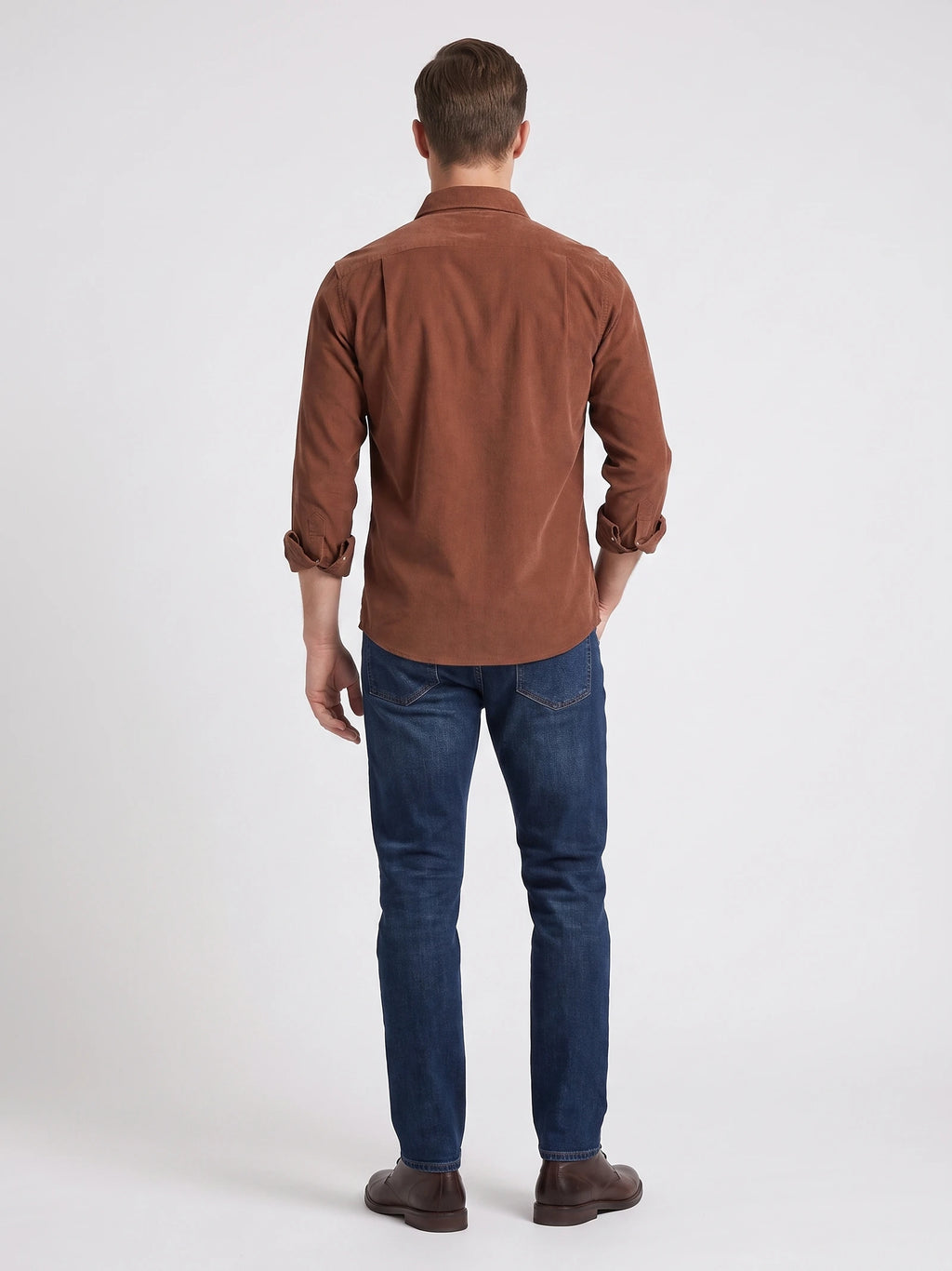 Rear studio view of a model wearing a Brown cotton corduroy shirt with rolled sleeves.
