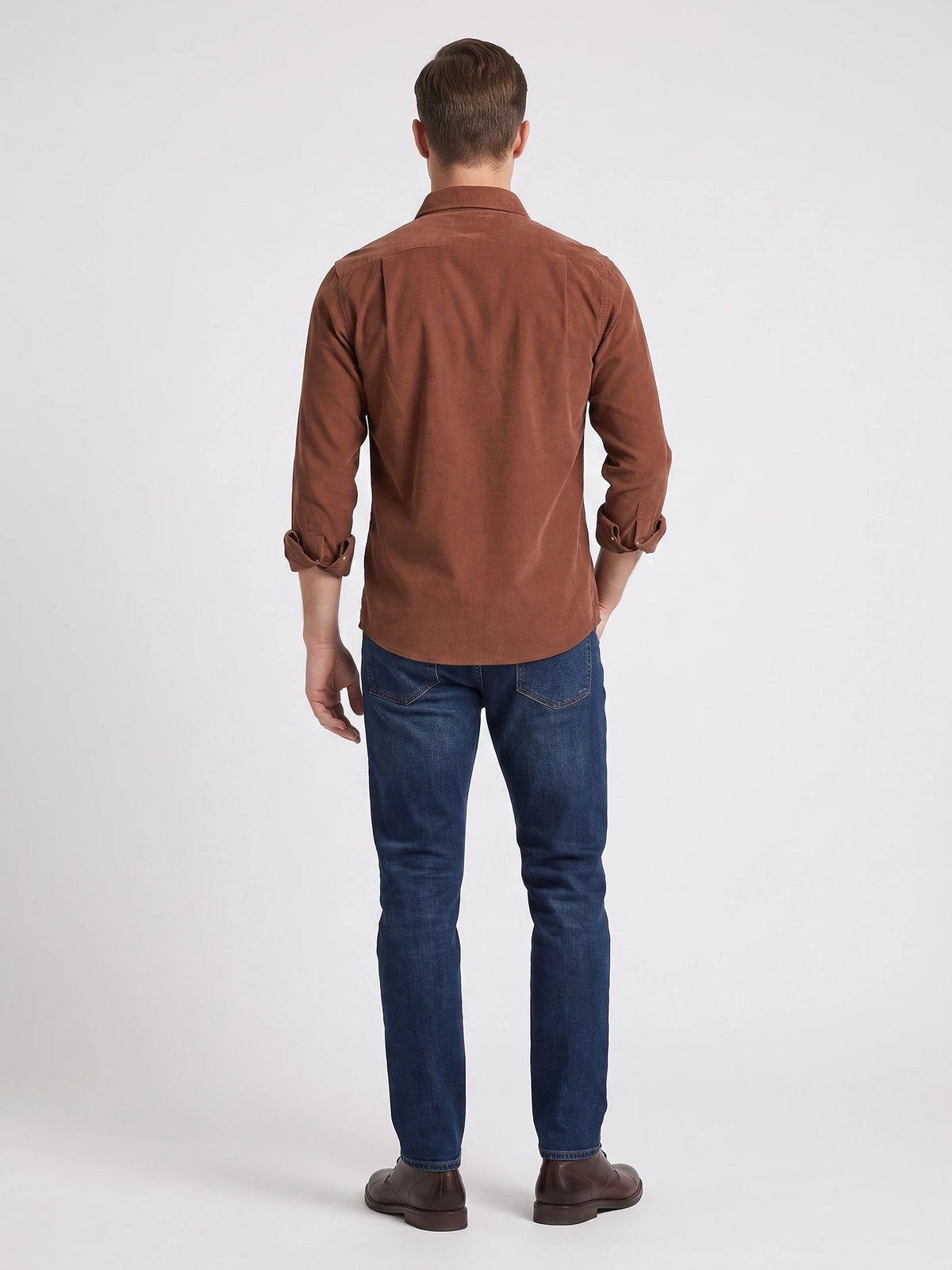 Rear studio view of a model wearing a Brown cotton corduroy shirt with rolled sleeves.