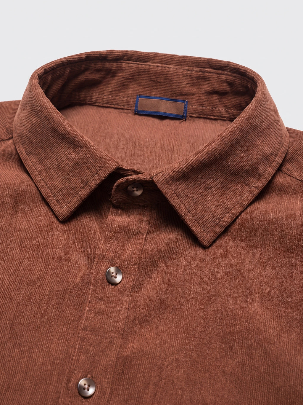 Close-up of the Brown men's Corduroy Shirt showcasing its pointed collar, button placket, and fine ribbed texture.