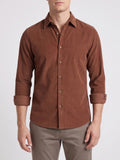 Front studio view of a model wearing a Brown cotton corduroy shirt with a button-front collar and rolled cuffs.