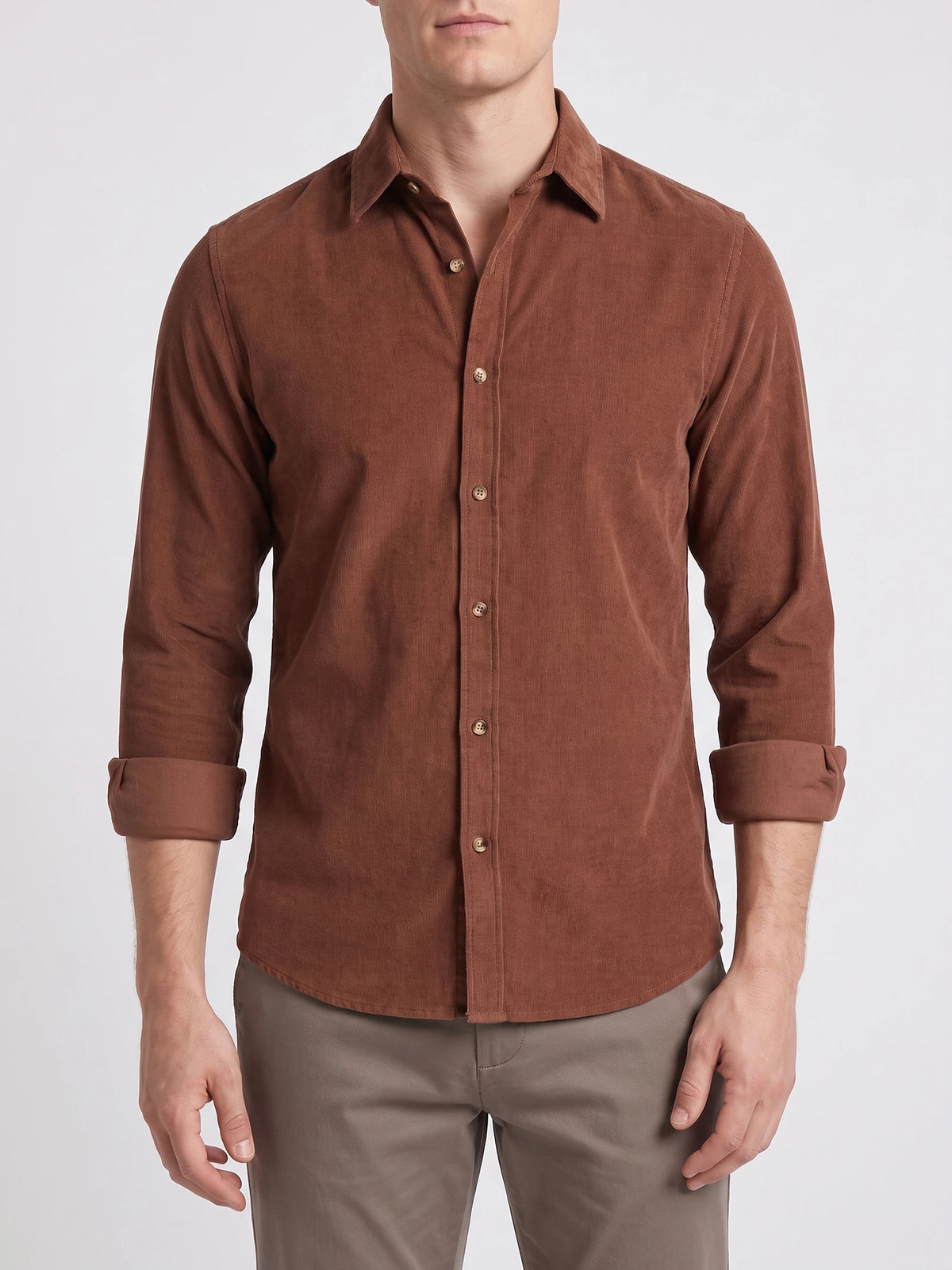 Front studio view of a model wearing a Brown cotton corduroy shirt with a button-front collar and rolled cuffs.