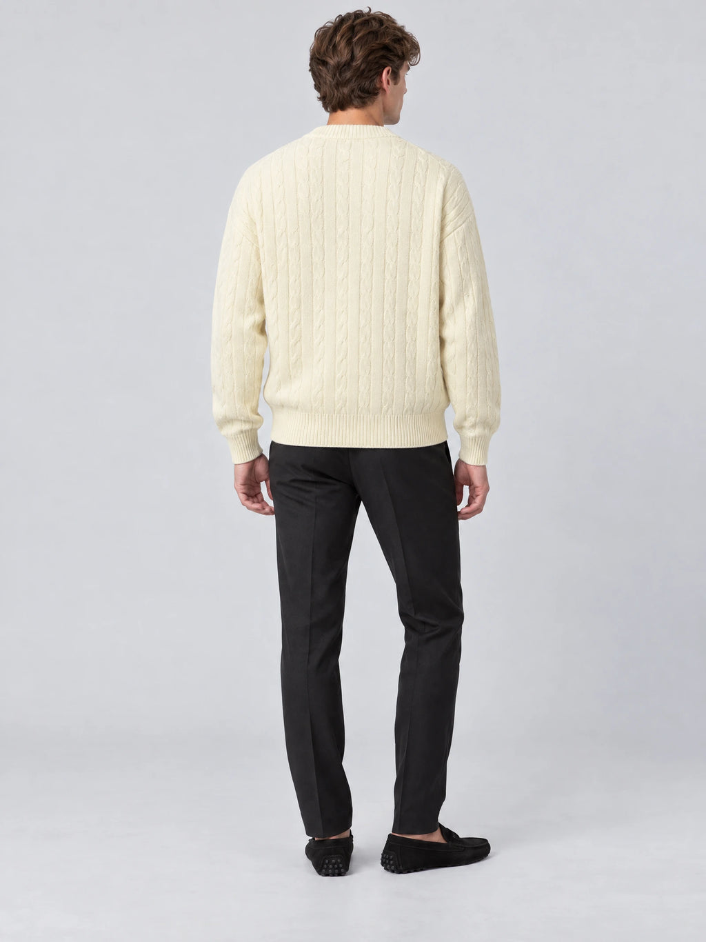 Rear studio view of a model wearing a Beige crewneck cardigan with cable-knit texture and ribbed trim.