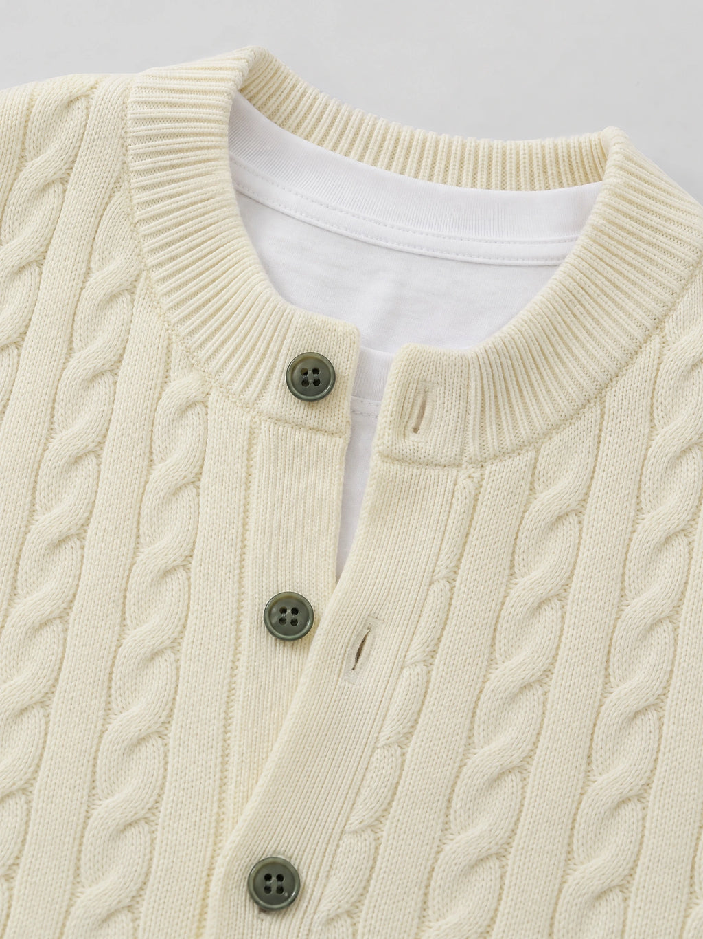 Beige crewneck cardigan close-up showing cable-knit texture, ribbed trim, and front button closure.