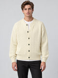 Front studio view of a model wearing a Beige crewneck cardigan with cable-knit texture, button front, and ribbed cuffs and hem.