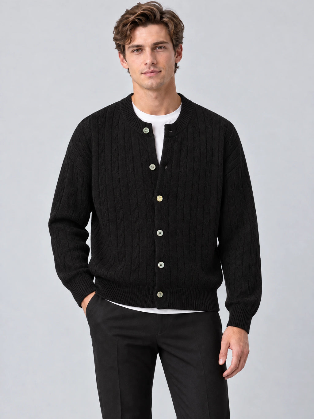Front studio view of a model wearing a Black crewneck cardigan with cable-knit texture, button front, and ribbed trim.