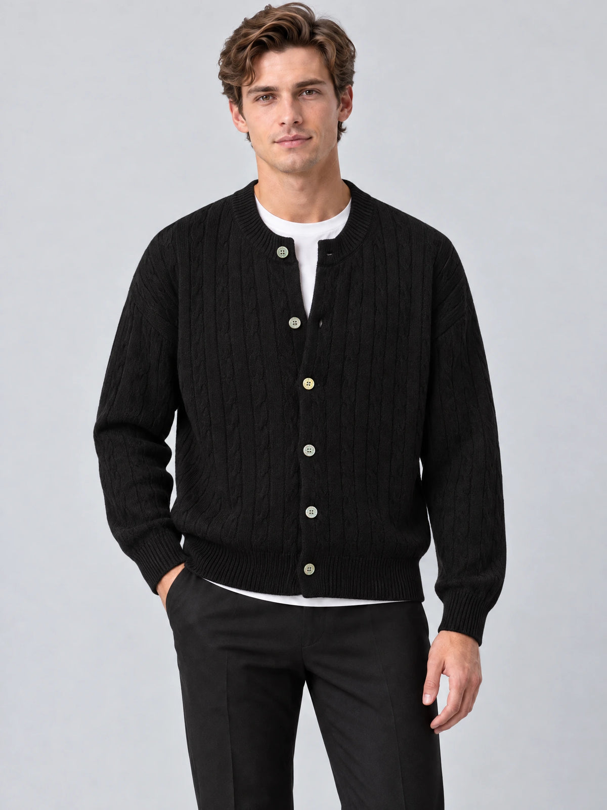 Front studio view of a model wearing a Black crewneck cardigan with cable-knit texture, button front, and ribbed trim.
