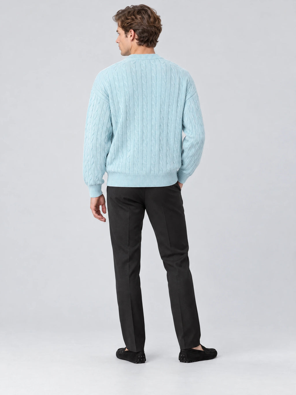 Back view of a model wearing a Blue crewneck cardigan with a cable-knit texture and ribbed hem.