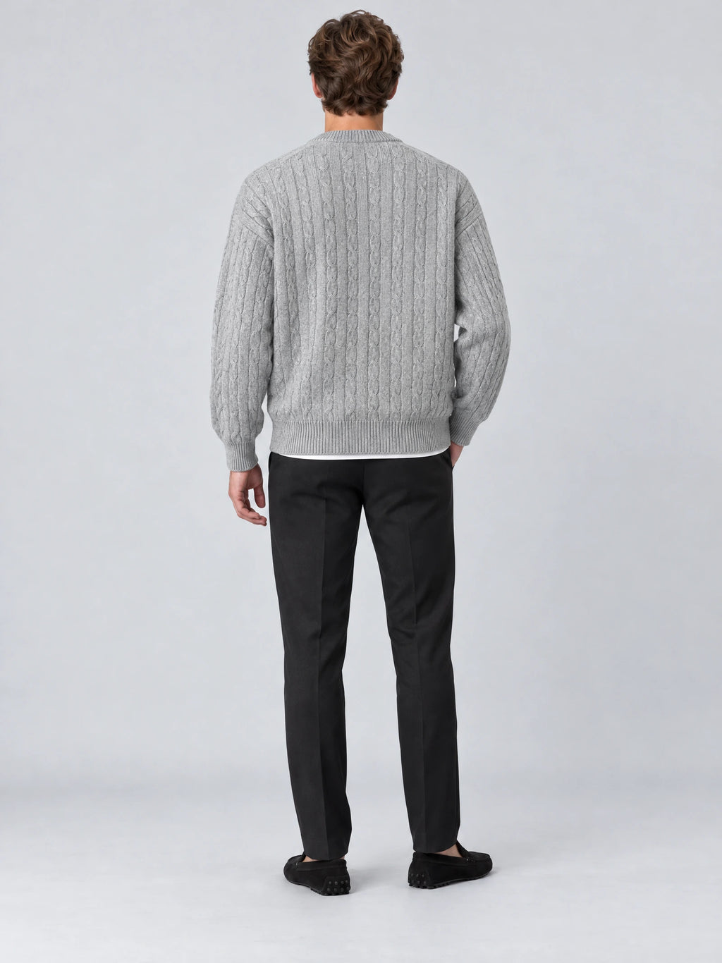 Rear studio view of a model wearing a Gray crewneck cardigan with a cable-knit texture and ribbed hem and cuffs.