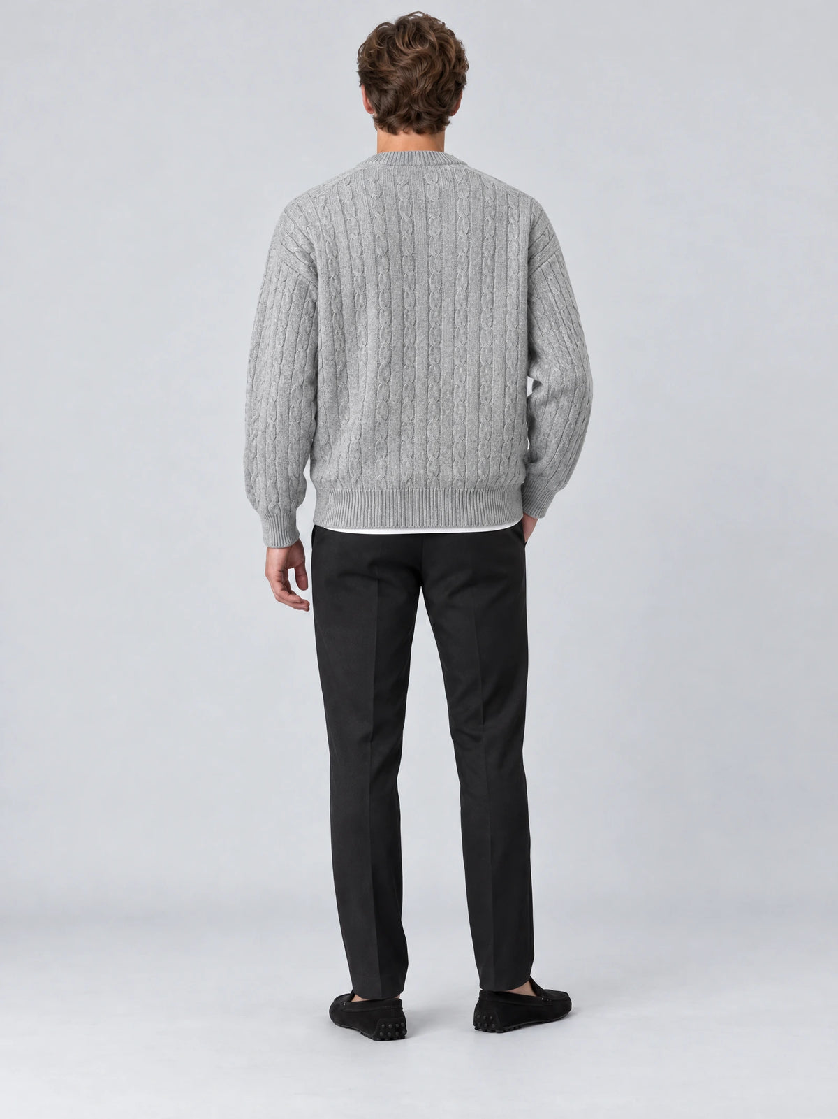Rear studio view of a model wearing a Gray crewneck cardigan with a cable-knit texture and ribbed hem and cuffs.