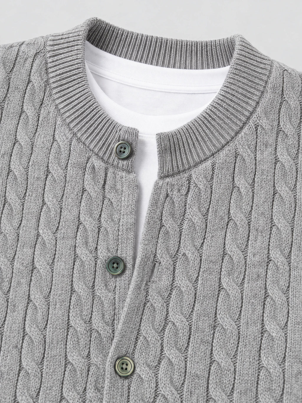 Close-up of a Gray crewneck cardigan with cable-knit texture, ribbed collar, and button-front closure.