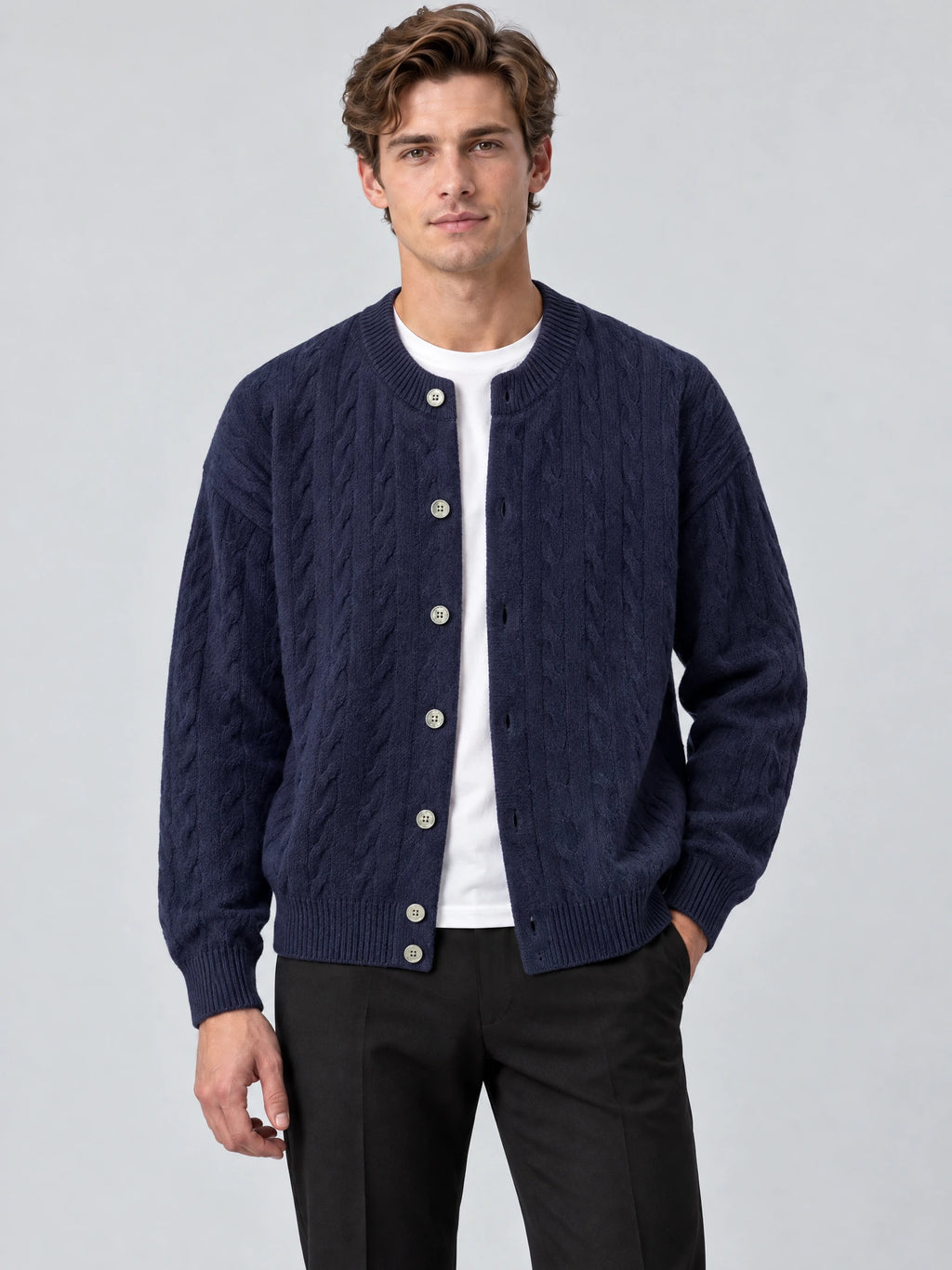 Front studio view of a model wearing a Navy crewneck cardigan with cable-knit texture, button front, and ribbed trim.