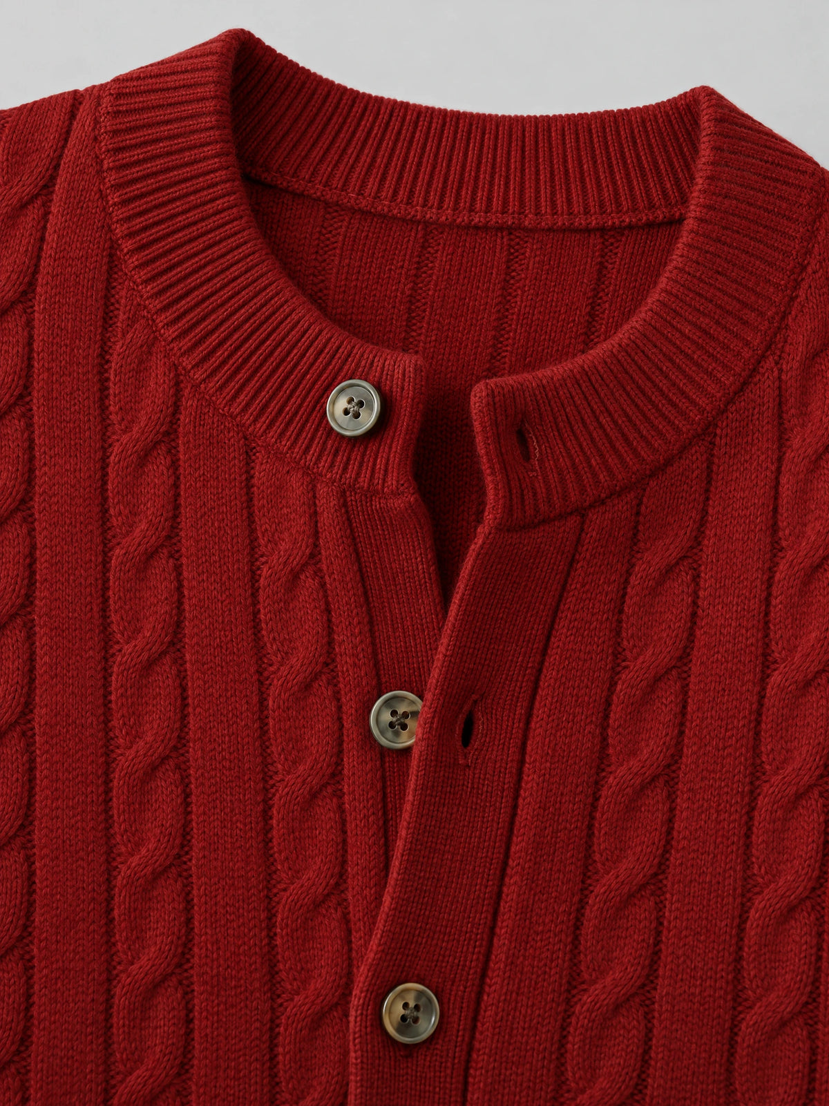 Close-up of the Red crewneck cardigan showing cable-knit texture, ribbed neckline, and button-front placket.