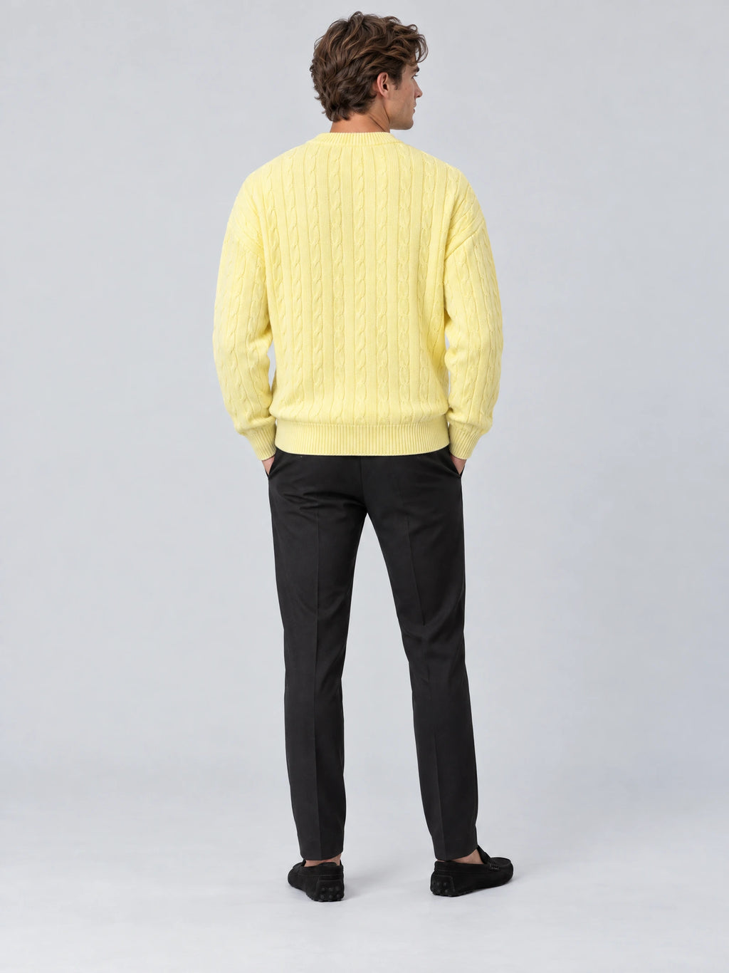 Rear studio view of a model wearing a Yellow crewneck cardigan with a cable-knit texture and ribbed hem.