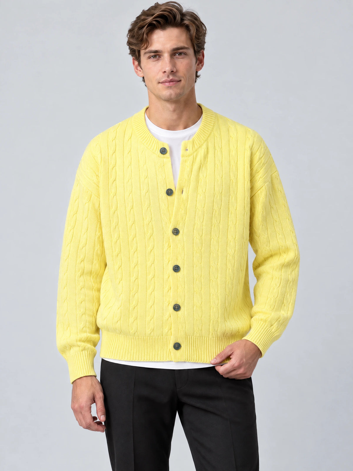 Front studio view of a model wearing a Yellow crewneck cardigan with cable-knit texture, button front, and ribbed cuffs and hem.