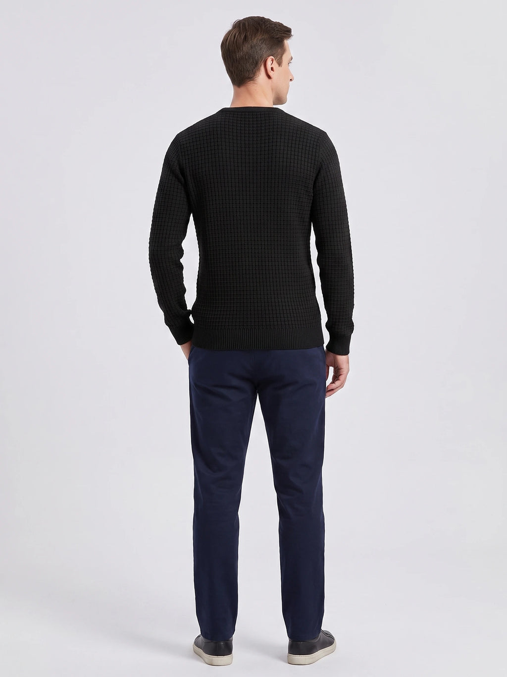 Rear studio view of a model wearing a Black men's crewneck sweater with textured knit and ribbed cuffs and hem.
