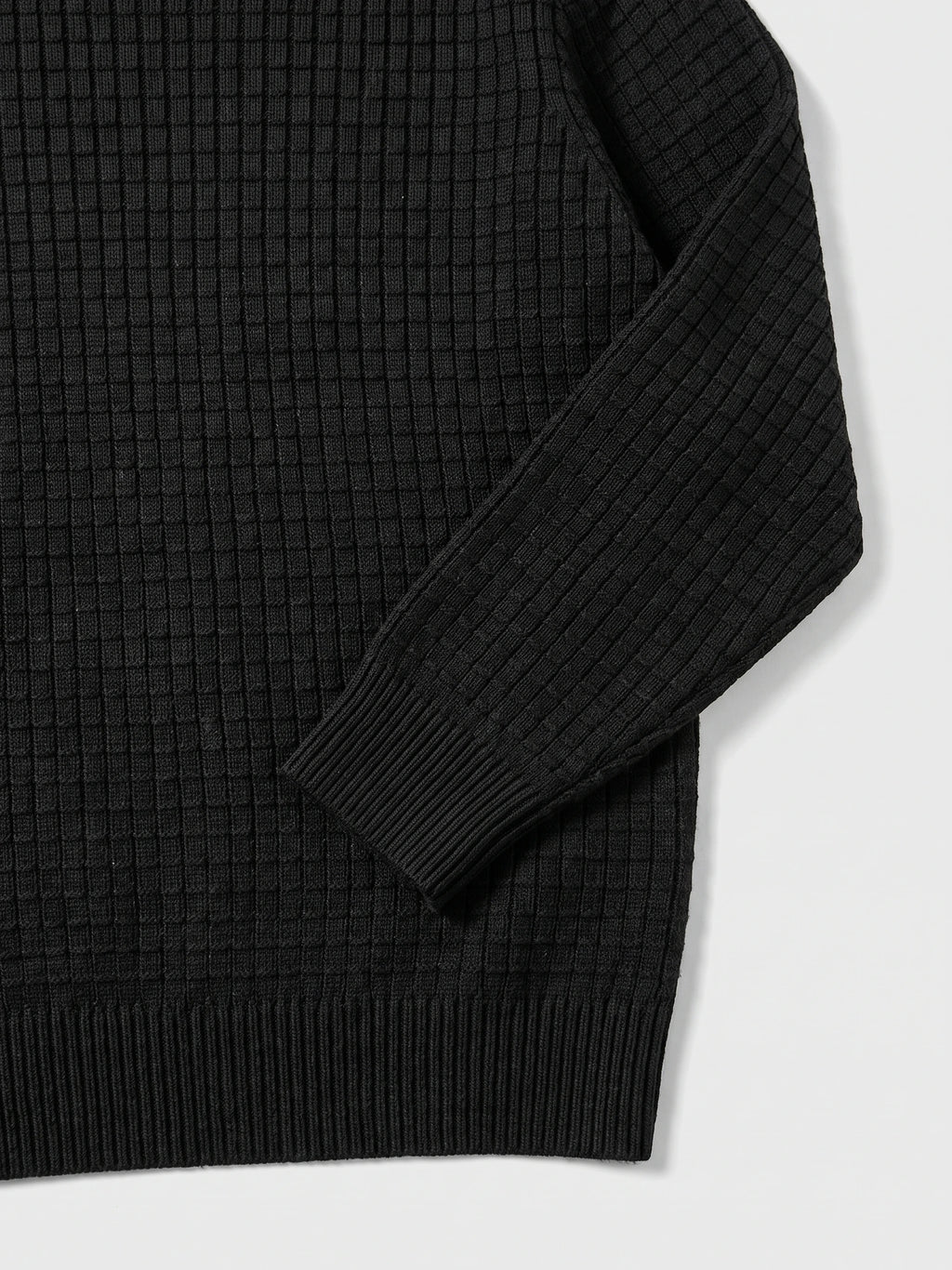 Black Men's Crewneck Sweater detail showing textured knit fabric, a ribbed cuff, and hem.